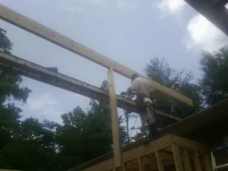 Carpenter setting a ridge beam over a new addition frame — Ice Dam Removal by Roofing Brothers in Ho Ho Kus