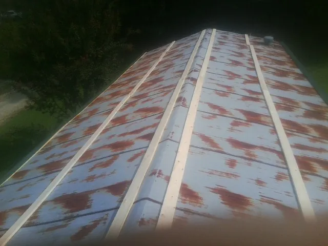 Rusted metal roof panels with new wood purlins before replacement — Storm Damage Roof Repair in Ho Ho Kus by Roofing Brothers