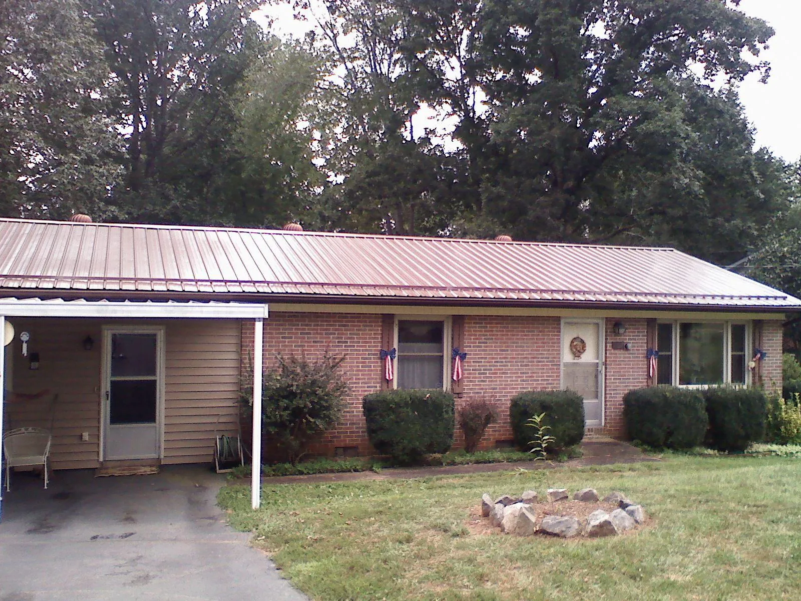 Bronze metal roof and carport on a brick ranch home — Roof Repair work by our crew in Ho Ho Kus
